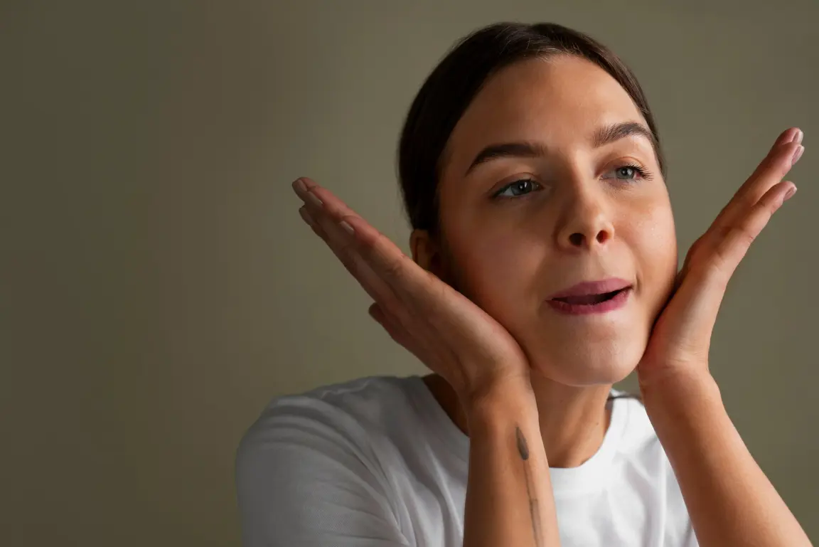 Woman gently pressing her cheeks during a skincare routine, showcasing healthy, smooth, and radiant skin.